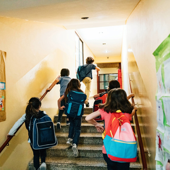 Young children entering school after their parents dropped them off.