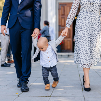 Parents walking out of their parish church after Mass, with their young son.